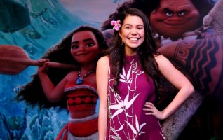 Auli'i Cravalho with Moana poster